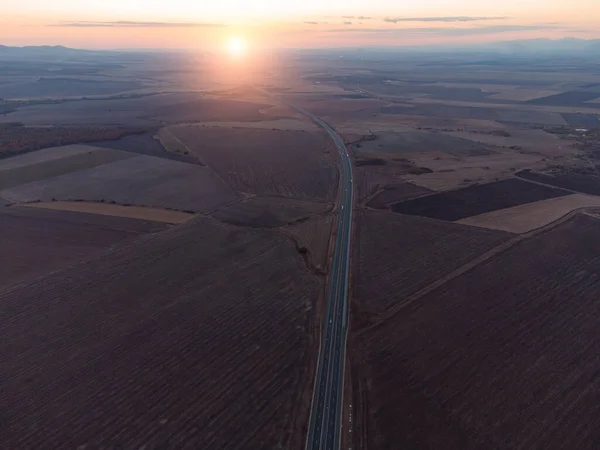 Aerial top view of highway road at sunset in autumn. Top view from drone of road