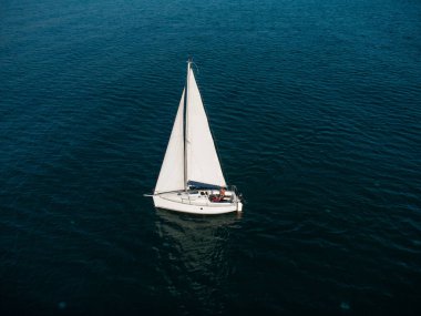 Yalnız yelkenli yatı deniz manzaralı.