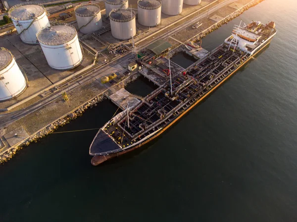 Aerial top view of oil ship tanker and lpg ship at industrial port at sunset