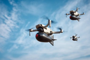 Üzerinde büyük bir plastik bomba olan üç tüketici sivil dronu mavi gökyüzünde uçuyor.
