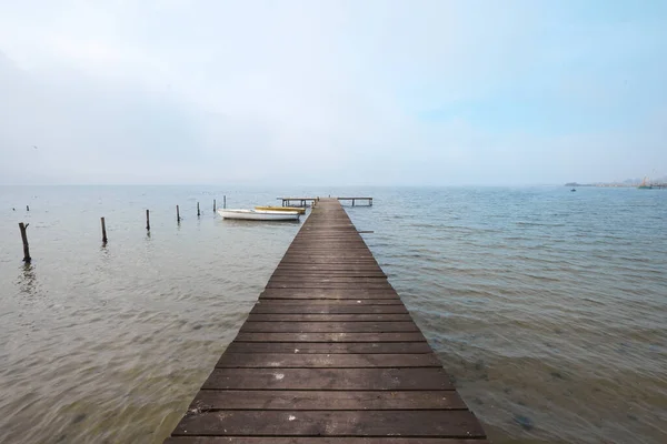 雾蒙蒙的湖面上的木制码头或码头 — 图库照片