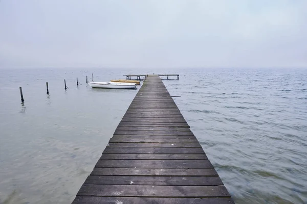 雾蒙蒙的湖面上的木制码头或码头 — 图库照片