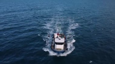 Mavi denizde yüzen balıkçı teknesi, İHA 'dan gökyüzü manzaralı..