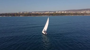 Yalnız yelkenli yatı deniz manzaralı.