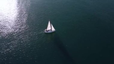 Yalnız yelkenli yatı deniz manzaralı.