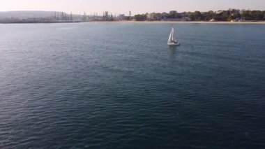 Yalnız yelkenli yatı deniz manzaralı.