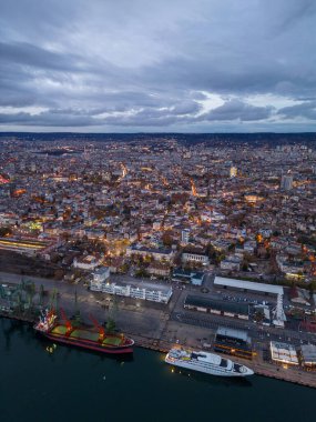 Gün batımında Varna limanının hava aracı görüntüsü. Gece şehir manzarası.