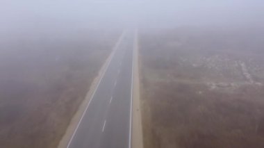 Asfalt karayolu sonbaharda sisli bir orman havası manzaralı.