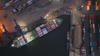 Konteynır gemisi, akşam havadan aşağıya İHA görünümünde limanda boşaltılıyor.