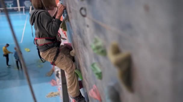 Восьмирічний Хлопчик Піднімається Скелелазну Штучну Стіну Залі — стокове відео