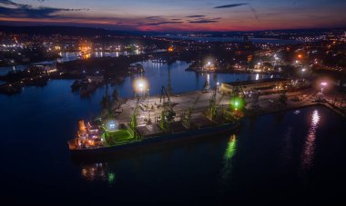 Büyük kargo gemisinin hava üst görüntüsü geceleri limanda buğday taneleri ile yükleniyor veya boşaltılıyor