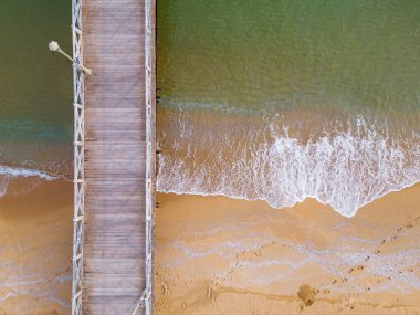 Denizde terk edilmiş ahşap bir iskelenin havadan aşağı manzarası.