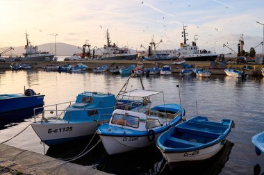 Sozopol, Bulgaristan - 18 Aralık 2022: Gün batımında yat limanında balıkçı tekneleri ve gemiler