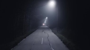 A trip on a rural forest road in a fog at night, flying drone video