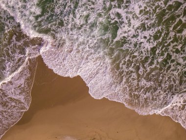 aerial top down view on a sandy beach with sea surf no people
