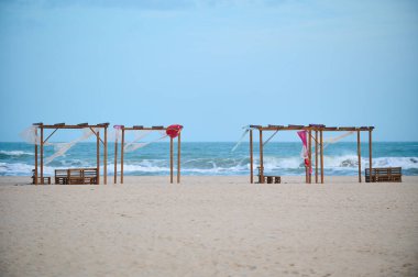 View of umbrellas and chairs on sandy beach and sea nobody. Empty beach waiting for tourists.