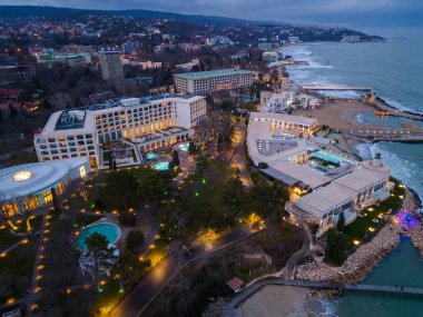 Aerial top view of several pools in the spa center on a sea coast at night