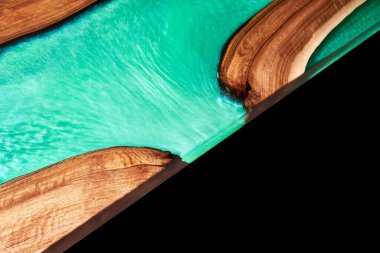 Texture of a wooden table with epoxy resin isolated on black closeup