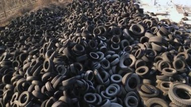 Aerial top down view of old tires dump. Many car and truck tires on dump site from above