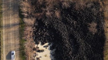 Aerial view of old tires dump near the highway. Many car and truck tires on dump site from above