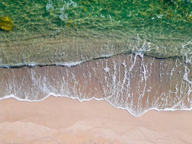 aerial top down view on sandy beach with sea surf slow motion nobody
