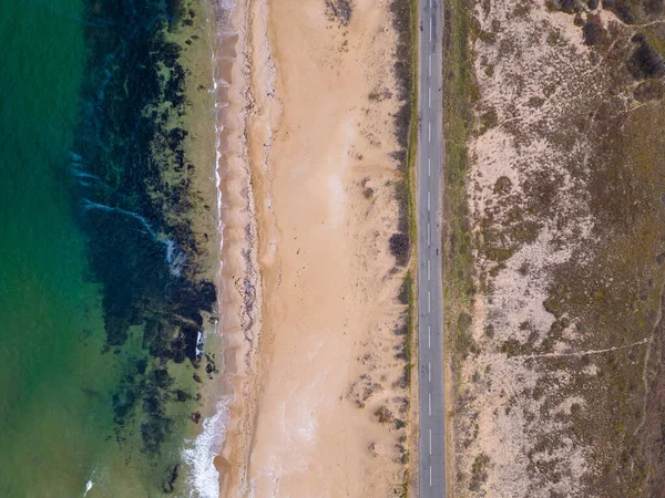 海の砂の海岸に沿って道路の空中ビュー 海沿いの道路を車で走ると — ストック写真