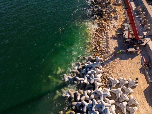 防波堤建筑的空中俯瞰 海里一堆巨石上的推土机和起重机 — 图库照片