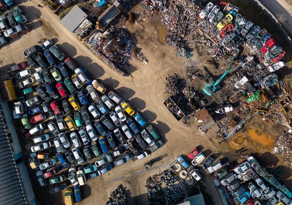 从空中观看汽车垃圾堆 在那里可以看到一台机器把旧车拆成碎片 从上面可以看到大量被遗弃的汽车和用于加工这些汽车的重型机械 — 图库照片