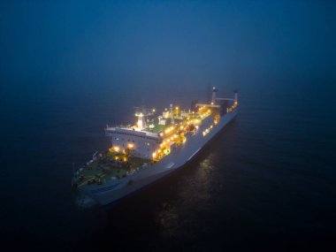 Denizdeki sisli koşullarda gece ilerleyen bir feribotun hava görüntüsü. Karanlık ortam, sisli koşullar ve feribotun varlığı ürkütücü bir şey yaratabilir.