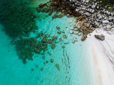 Yunan adası Thassos 'ta beyaz mermer çakıl taşları ve turkuaz deniz bulunan sahil nefes kesici bir doğa harikasıdır. Hava görüntüsü. Canlı mavi karşısında el değmemiş beyaz çakıl taşlarının kontrastı