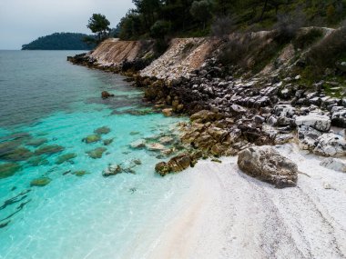 Yunan adası Thassos 'ta beyaz mermer çakıl taşları ve turkuaz deniz bulunan sahil nefes kesici bir doğa harikasıdır. Hava görüntüsü. Canlı mavi karşısında el değmemiş beyaz çakıl taşlarının kontrastı