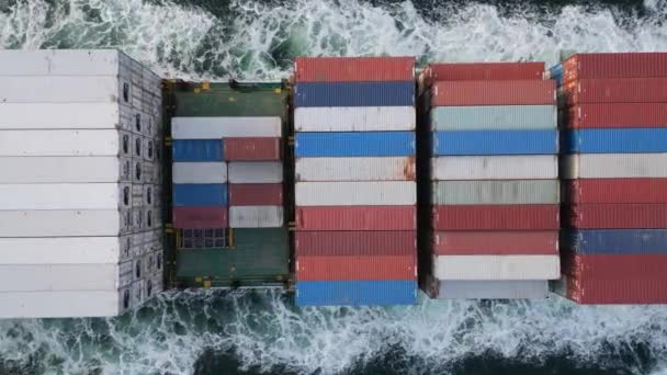 集装箱船在海上航行的空中俯瞰 其巨大的船体在全世界运送货物时划破了水面 船被无休止的波浪包围着 — 图库视频影像