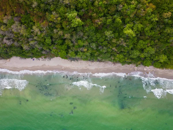 从上面看去 迷人的海滩展开 金黄的沙滩被青绿色的波浪爱抚着 茂密的绿林点缀着海岸线 坚固的岩石增添了一种粗犷的魅力 — 图库照片