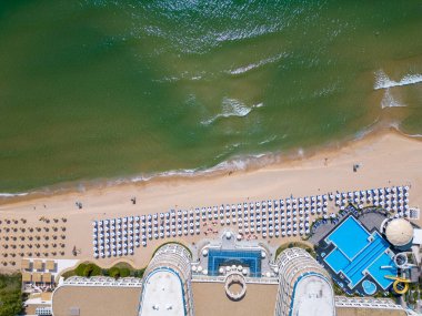 Deniz kenarına kurulmuş, nefes kesen okyanus manzarası ve lüks konforlarla övünen özel bir konut kompleksinin çarpıcı bir üst görüntüsü..