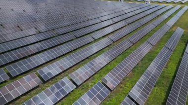 Bereketli bir çayır ve ormanın ortasında güneş panelleri, güneşin enerjisinden yararlanmak için uzun süre ayakta kalır. Işıl ışıl yüzeyleri, canlı gökyüzünü yansıtarak büyüleyici bir görüntü yaratıyor. İnsansız hava araçlarından yakalanmış.