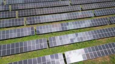 Bereketli bir çayır ve ormanın ortasında güneş panelleri, güneşin enerjisinden yararlanmak için uzun süre ayakta kalır. Işıl ışıl yüzeyleri, canlı gökyüzünü yansıtarak büyüleyici bir görüntü yaratıyor. İnsansız hava araçlarından yakalanmış.