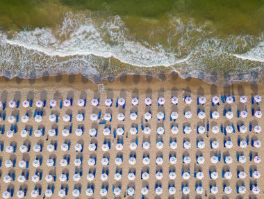 Saman plaj şemsiyeleri ve turkuaz berrak suyla inanılmaz boş bir kumsal manzarası..
