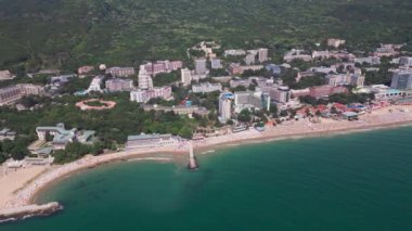 Bulgar Altın Kumlar tatil beldesinin yaz mevsiminde havadan görünen manzarası: bir dizi otel, havuz ve denizin keyfini çıkaran insan.
