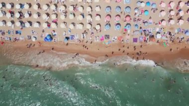 Bulgar Altın Kumlar tatil beldesinin yaz mevsiminde havadan görünen manzarası: bir dizi otel, havuz ve denizin keyfini çıkaran insan.