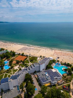 Bulgarias Albena Sands 'in yaz sezonundaki havadan görünüşü: bir dizi otel, havuz ve denizin keyfini çıkaran insan.
