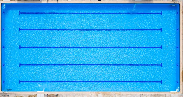 Güneş ışınları spor havuzunun köpüklü sularında dans ederek yüzücülerin olmadığı sihirli bir manzara yaratıyor. Hava aracı görünümü