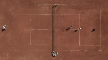 Yukarıdan panoramik bir hava görüntüsü tenis antrenmanını kaydediyor. Sahadaki oyuncular her vuruşta yetenek ve coşku gösteriyorlar..