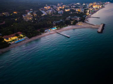 Bulgar tatil beldelerinin kıyı şeridinin büyüleyici insansız hava aracı görüntüsü. Parıldayan ışıklar ve huzur dolu gece büyüsü.