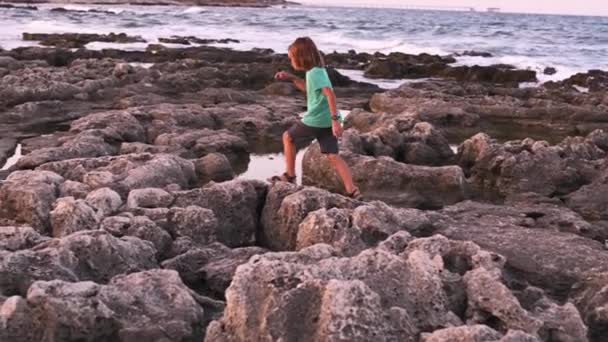 Ein Jähriger Junge Mit Langen Hellen Haaren Springt Gekonnt Felsigen — Stockvideo