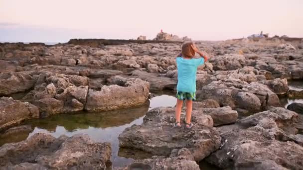 Pětiletý Chlapec Dlouhými Světlými Vlasy Hbitě Skáče Podél Skalnatého Moře — Stock video