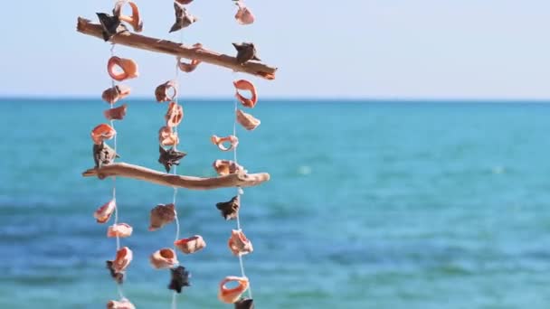 Κοχύλια Κρεμασμένα Ένα Σχοινί Ταλαντεύεται Στον Άνεμο Από Γαλάζια Θάλασσα — Αρχείο Βίντεο