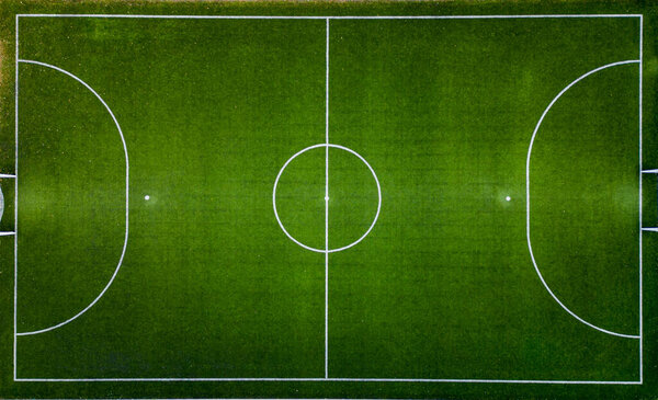 Top down aerial view of an empty green soccer field, awaiting the joyous moments of the game.