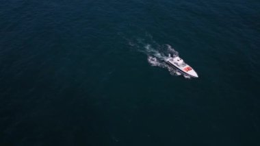Deniz dalgalarında yarışan bir zevk teknesinin hava aracı görüntüsü hız ve özgürlüğün büyüleyici bir resmini oluşturuyor..