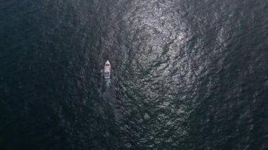 Deniz dalgalarında yarışan bir zevk teknesinin hava aracı görüntüsü hız ve özgürlüğün büyüleyici bir resmini oluşturuyor..