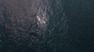 Deniz dalgalarında yarışan bir zevk teknesinin hava aracı görüntüsü hız ve özgürlüğün büyüleyici bir resmini oluşturuyor..